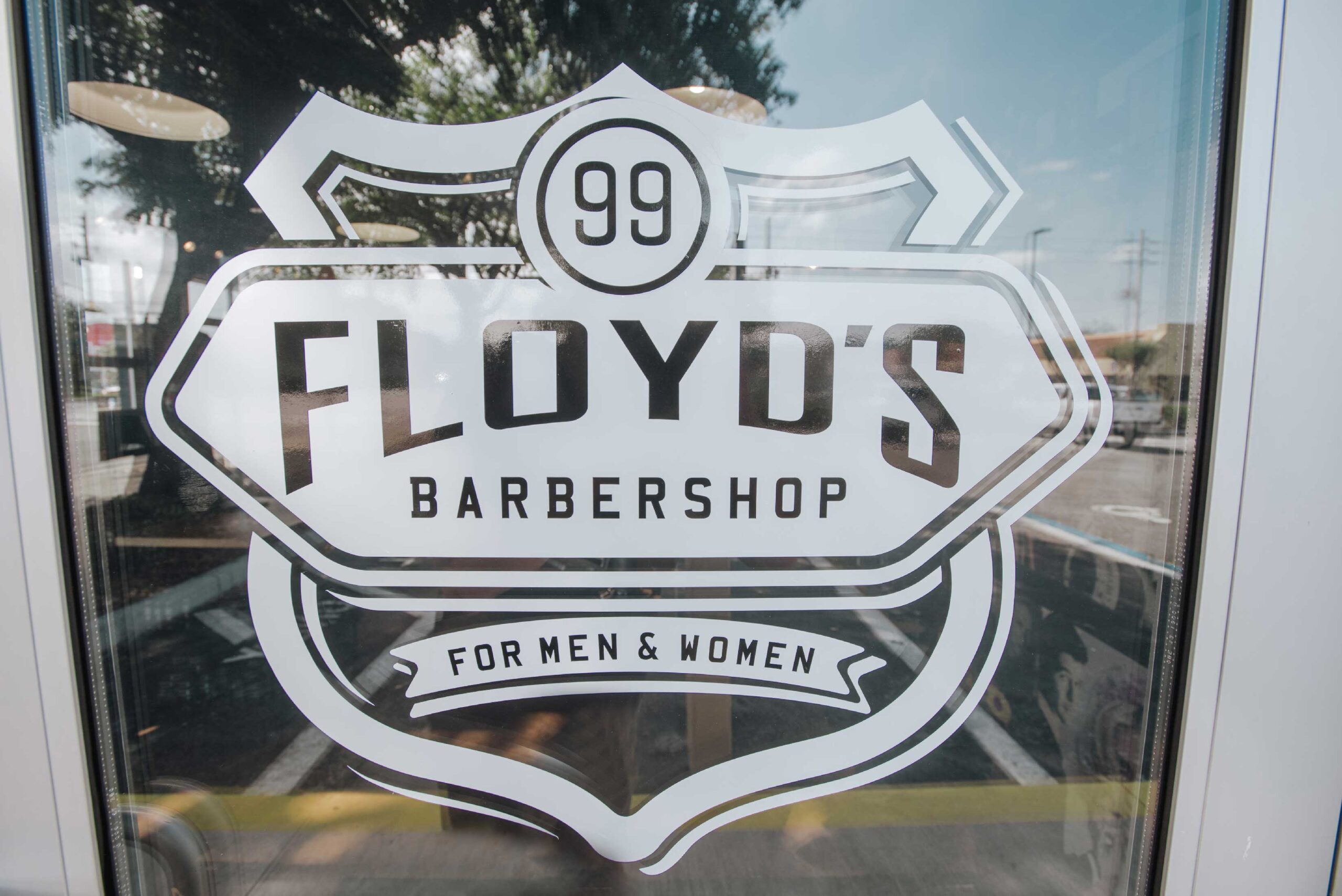 Floyd's Barbershop logo decal on glass