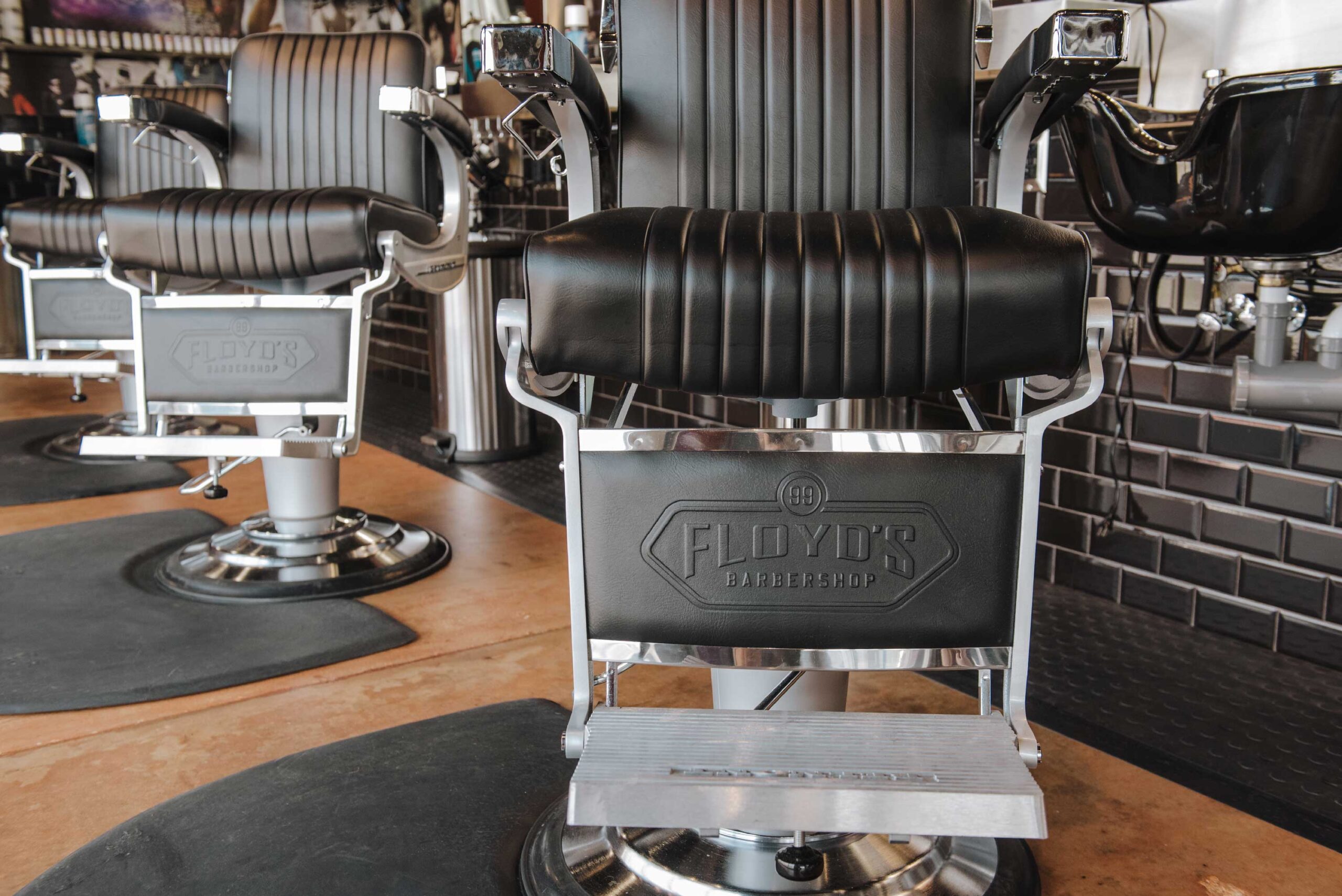 Floyd's Barbershop barber chairs with logo detail in foot area